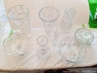 Overview of all 8 crystal pieces including bowls and vases with clear and intricate cut patterns.