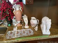 View of all items including pitcher, vase, tray, ceramic hand, elephant figurine, angel figurine placed together on countertop