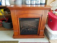 Front view of the Dimplex electric fireplace, showing wooden frame and electric fire insert.