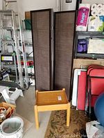 Room divider panels and small wood end table shown in a garage/storage space with other household items.