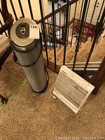 Bionaire air purifier and Holmes fan shown side by side on carpeted stairs.