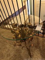 Top down view of hand-painted gold floral metal base with glass top removed.