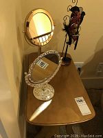 View of gold lacquer end table with two mirrors and jewelry stand placed on the table.