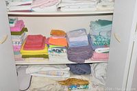 Close-up of folded towels and linens showing color variety and condition.