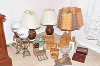 Photo showing 5 table lamps of different styles along with handcrafted Cuban wooden boxes and other decorative items grouped on a surface.