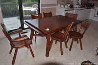 Full view of solid wood dining table with six matching chairs in kitchen area