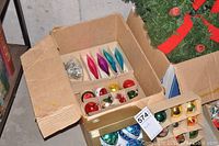 Close-up of box containing vintage glass bulbs in teardrop and round shapes with silver tinsel garland