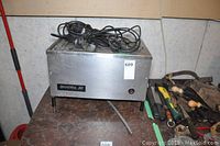 Front and side view of the Durastill 30 water distiller showing Stainless steel body, labeling and power cord.