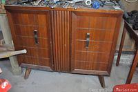 Front view of large wooden stereo cabinet with two doors and fluted center panel, showing condition and overall style.