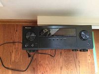 Front view of Pioneer amplifier and receiver showing volume knob, input selector, and display panel