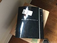 Sony PlayStation 3 console with visible PlayStation 3 branding on a brown box