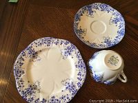 Single cup, saucer and side plate showing cobalt blue floral splatter border and backstamp