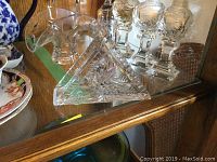 Crystal basket with curved handle featuring pinwheel cut pattern.