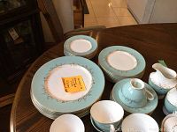 Overall view showing stacks of dinner and side plates, teacups, saucers, covered sugar bowls and creamer.