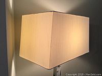 Close-up of the rectangular cream/off-white fabric lamp shade illuminated, showing clean and good condition.