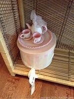 Miniature pink ceramic tea set placed on woven shelf showing all items in closed storage container.