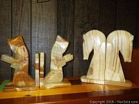 Two sets of onyx bookends displayed side by side against a dark wood background, showing front and side views of each.