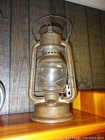 Side angle showing full antique Beacon lantern with visible rust and glass globe intact