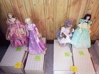 All four Franklin dolls on original storage boxes against wood-paneled wall