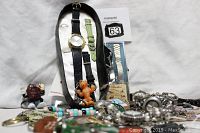 Overall shot of vintage watches, watch bands, and character key chains including California Raisin and teddy bear figures.