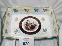 Photo showing the full front view of the rectangular serving tray, highlighting the central painted image, floral gold accents, and gold etched rim.
