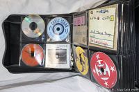 Open sleeved CD case showing multiple CDs in transparent sleeves, including Chris Isaak and Lemonheads CDs.
