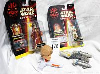 Two new-in-package Star Wars Episode I action figures with loose vehicles and a head sculpt accessory on a white background.