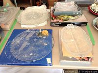 Glass plates on table including details of etchings and packaging boxes