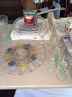 Photo of round floral accented glass plate, drinking glasses, and boxed ceramic dip chillers