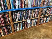 Shelf view of DVDs featuring various titles and genres, showing a large collection stored horizontally.