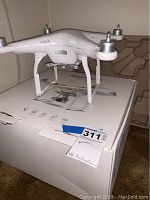 Side view of the white Phantom 3 drone body on its box showing the overall body shape and lack of accessories.