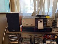 Photo of Pioneer stereo receiver and two TEAC speakers on shelf with CDs below.