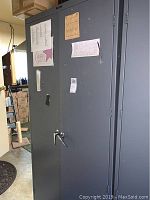 Front and side views of gray metal cabinet showing size and locking handles