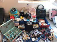Full lot overview showing jewelry boxes, assorted jewelry pieces, jewelry pouches, handbag, and bangles