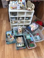 Overview of the craft supplies including storage unit, boxes and bags of beads, shells, ribbons.