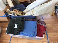 Tub containing folded and rolled fabrics in various colors and patterns