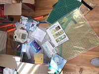 Assorted quilting rulers in various shapes and sizes scattered on floor including packaged and unboxed items