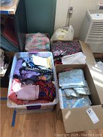 Four containers holding folded yardage and remnants in assorted colors and prints