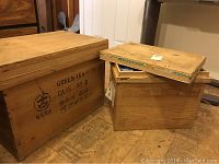Two wooden tea crates with removable lids, showing exterior with stamped Asian text and branding.