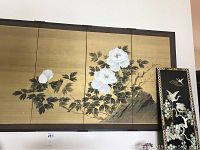 Full view of the silk screen panel with white peony flowers on a gold background alongside the lacquer and mother of pearl smaller screen panel.
