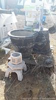 Wide shot showing two large weathered stone planters, the stone garden lantern base, and the Acurite weather center box placed outdoors.