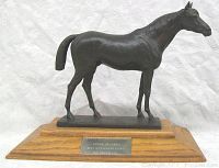 Full side view of sculpture on wood base showing horse profile