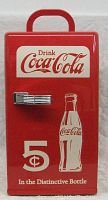 Front view of the portable Coca Cola fridge showing the red door with vintage Coca Cola design, chrome handle, and 5-cent price logo.