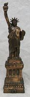 Front view of the metal Statue of Liberty figurine showing details of the torch, face, and pedestal base.