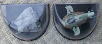 Both Star Wars Titanium Series diecast models in black semi-circular display cases showing top-down views of the Snowspeeder and Slave 1 ships, with details and paintwork visible.