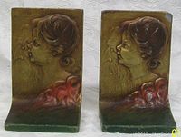 Front view of the pair of Art Nouveau cold painted metal bookends depicting young woman and older man profiles