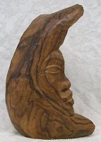 Side view of the wooden carved Aboriginal spirit statue showing profile of face and natural wood grain.
