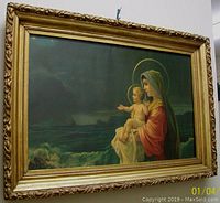 Framed print with image of Mary holding baby Jesus, showing full artwork and frame.