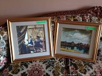 Two framed classical prints on vintage floral couch showing general look and frames' condition