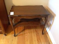 Full view of the solid wood side table showing top, legs, and lower shelf.